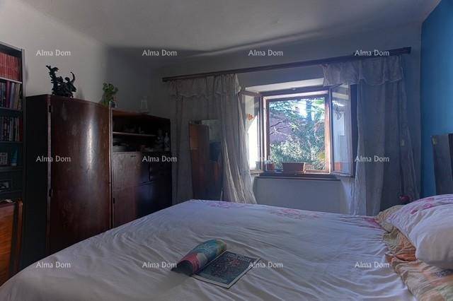 Geräumiges Schlafzimmer mit großem Bett und Kleiderschrank, das einen Ausblick ins Grüne bietet.