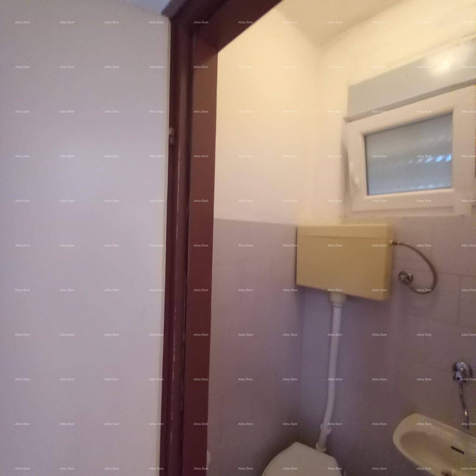 Kleines WC mit Toilette und Waschbecken, ausgestattet mit einfachen Fliesen und einem Fenster.