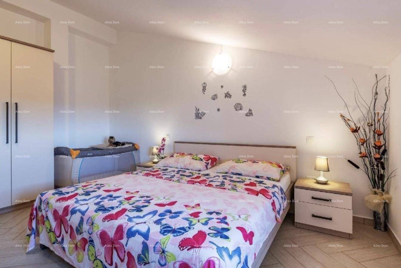 Schlafzimmer mit Doppelbett, Nachttischen und einem Babybett in der Ecke.