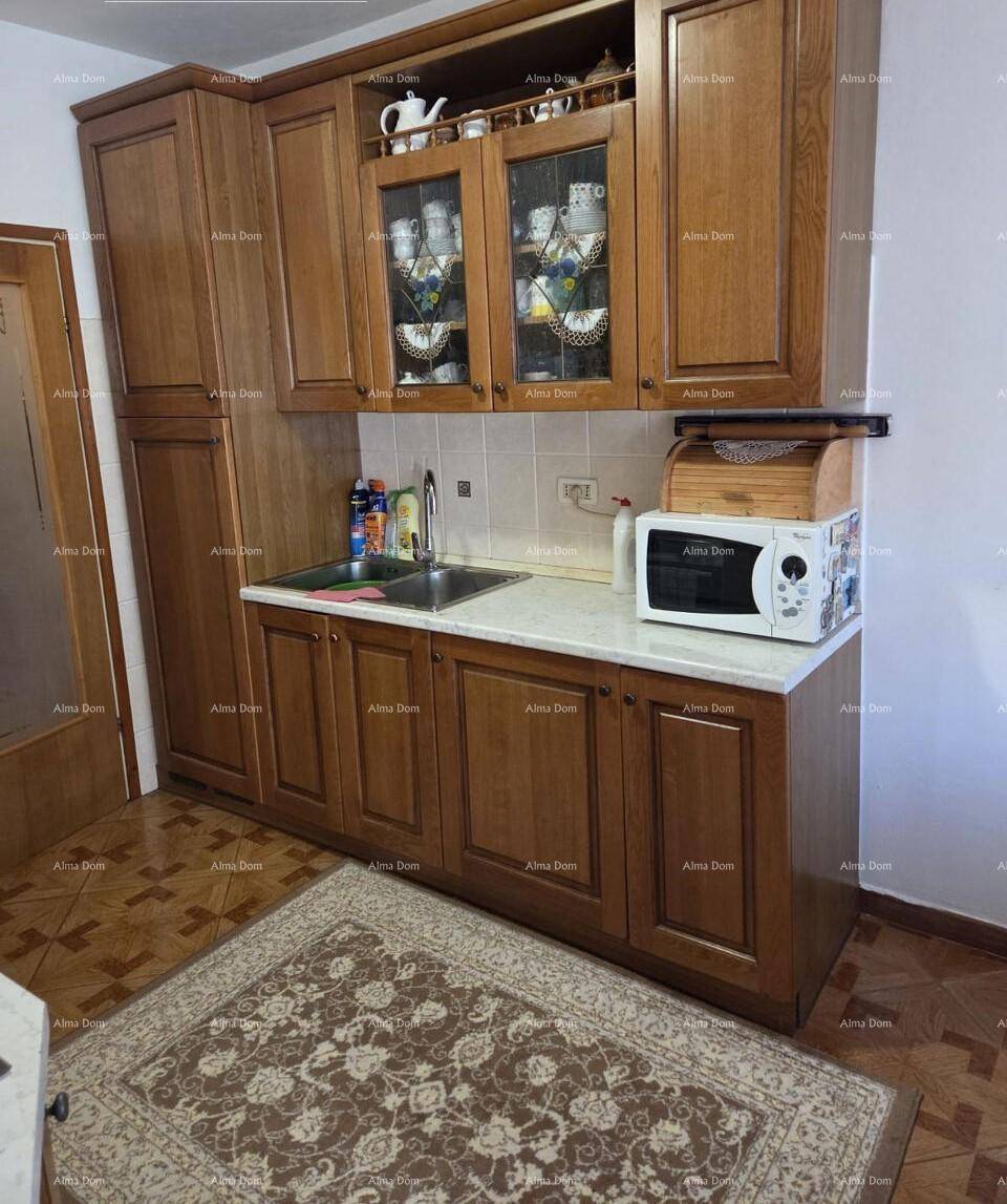 Funktionale Küche mit Holzschränken, Spüle und Mikrowelle, ausgestattet mit einem Teppich.