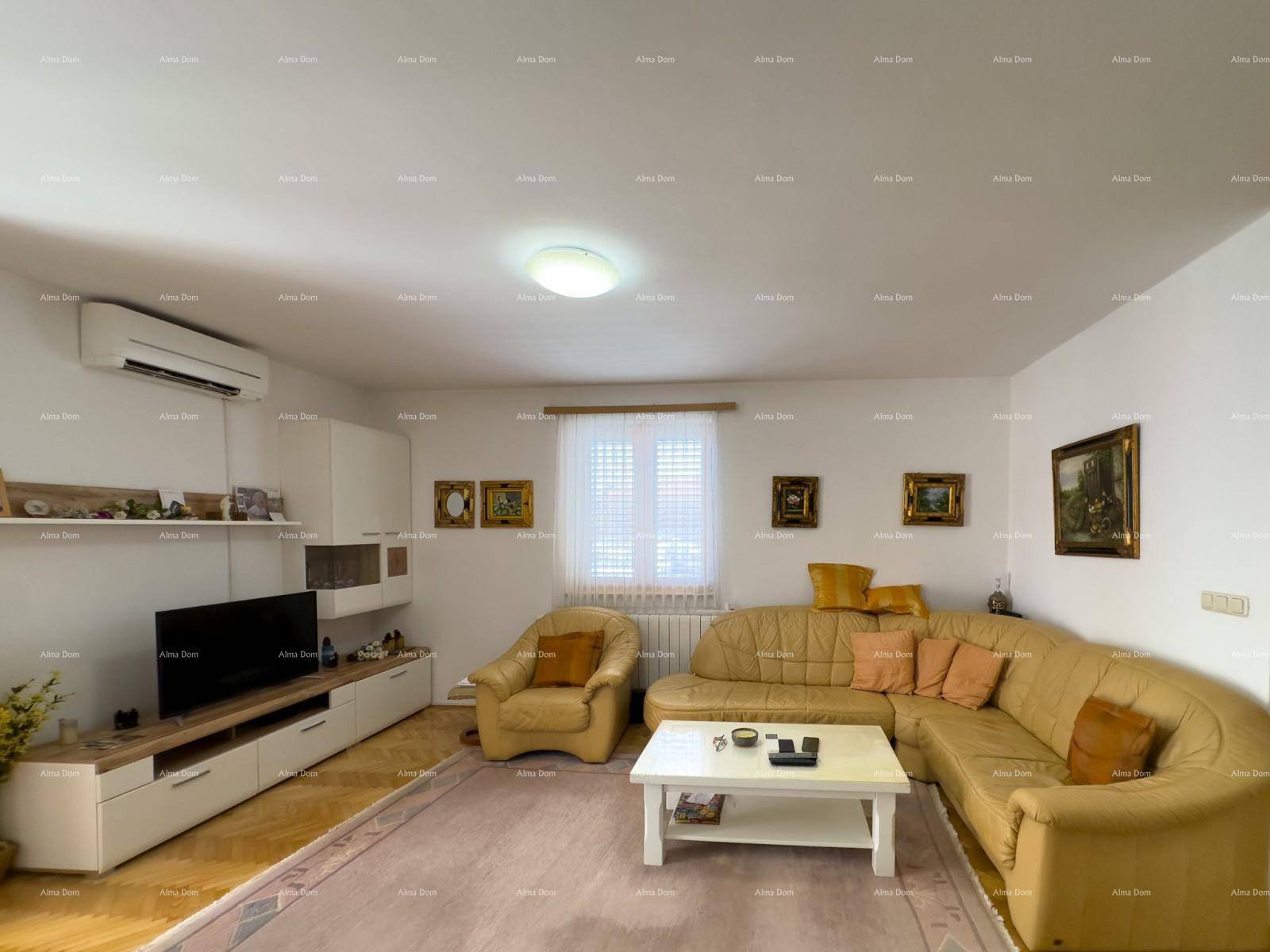 Helles Wohnzimmer mit beiger Eckcouch, Fernseher und Klimaanlage.