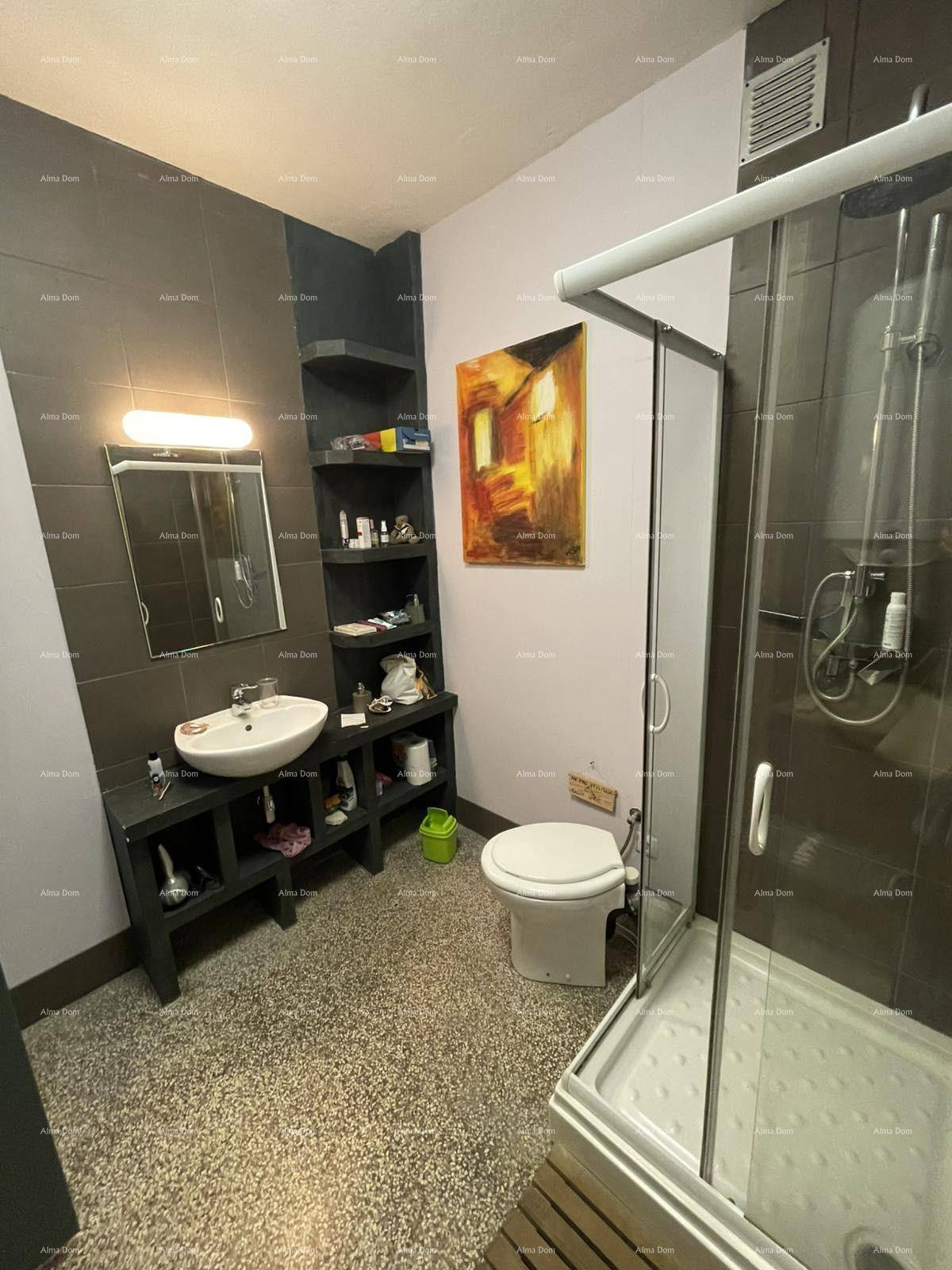 Modernes Badezimmer mit Dusche, Waschbecken und Toilette, in dunklen Farbtönen gehalten.