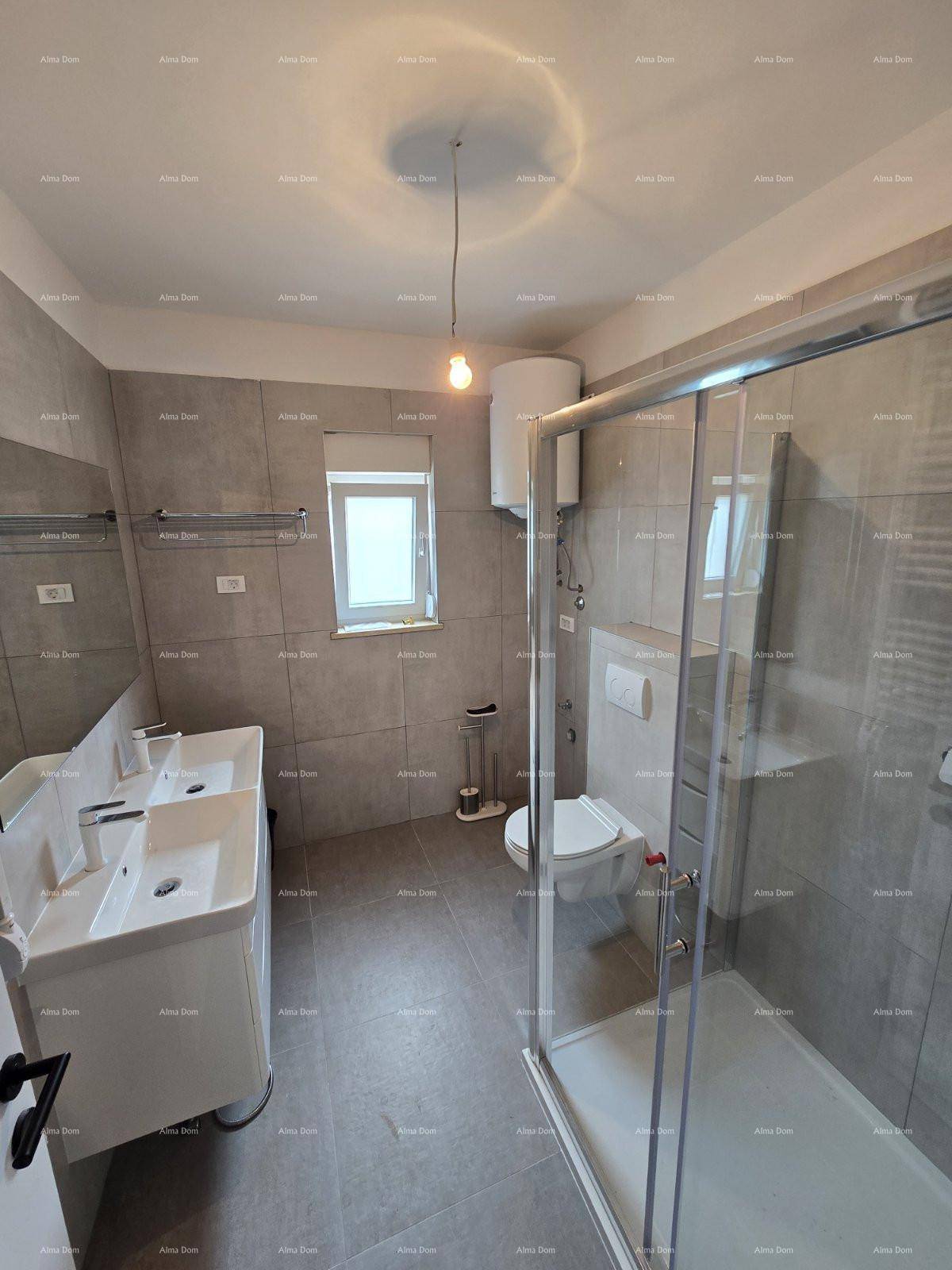 Modernes Badezimmer mit Doppelwaschbecken, Duschkabine, WC und grauen Fliesen an Wänden und Boden.