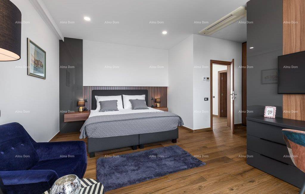 Geräumiges Schlafzimmer mit Doppelbett, blauer Akzentwand und Holzboden.