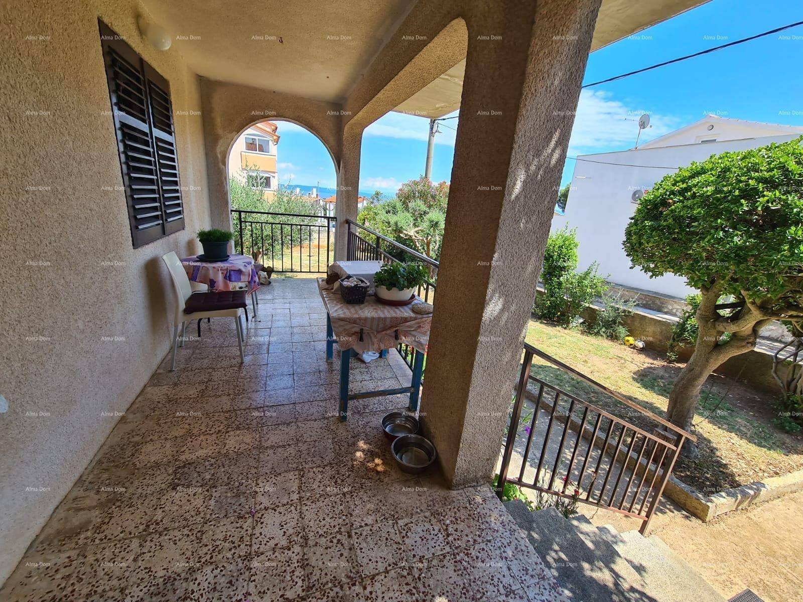 Geräumige überdachte Loggia mit gefliestem Boden und Blick auf den Garten.