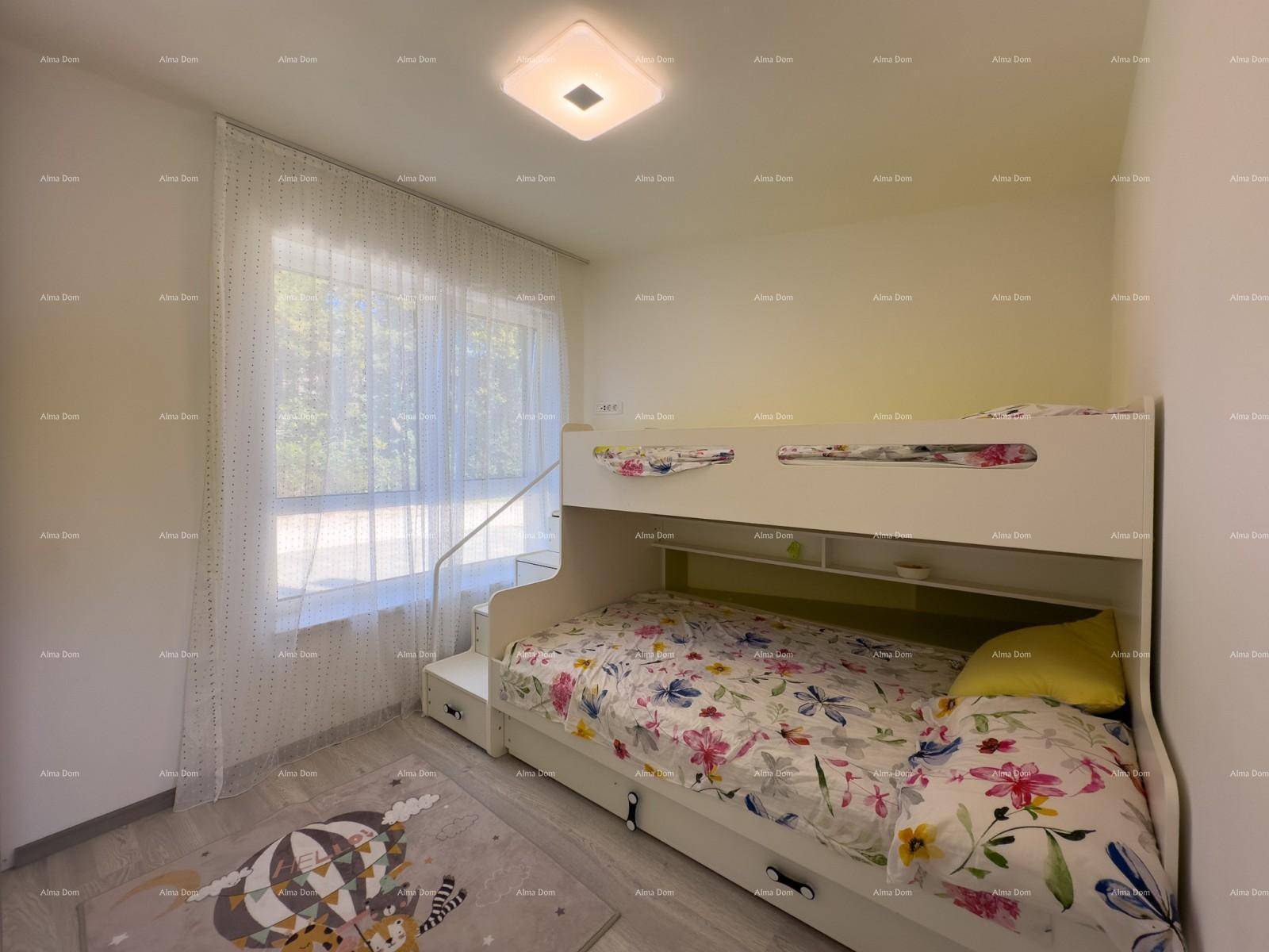 Kinderzimmer mit Etagenbett, hellem Fenster und farbenfroher Bettwäsche.
