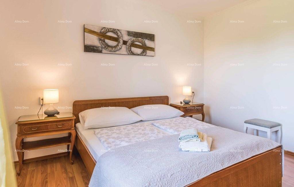 Gemütliches Schlafzimmer mit Doppelbett, zwei Nachttischen und Holzboden, dekoriert mit einem Wandbild.