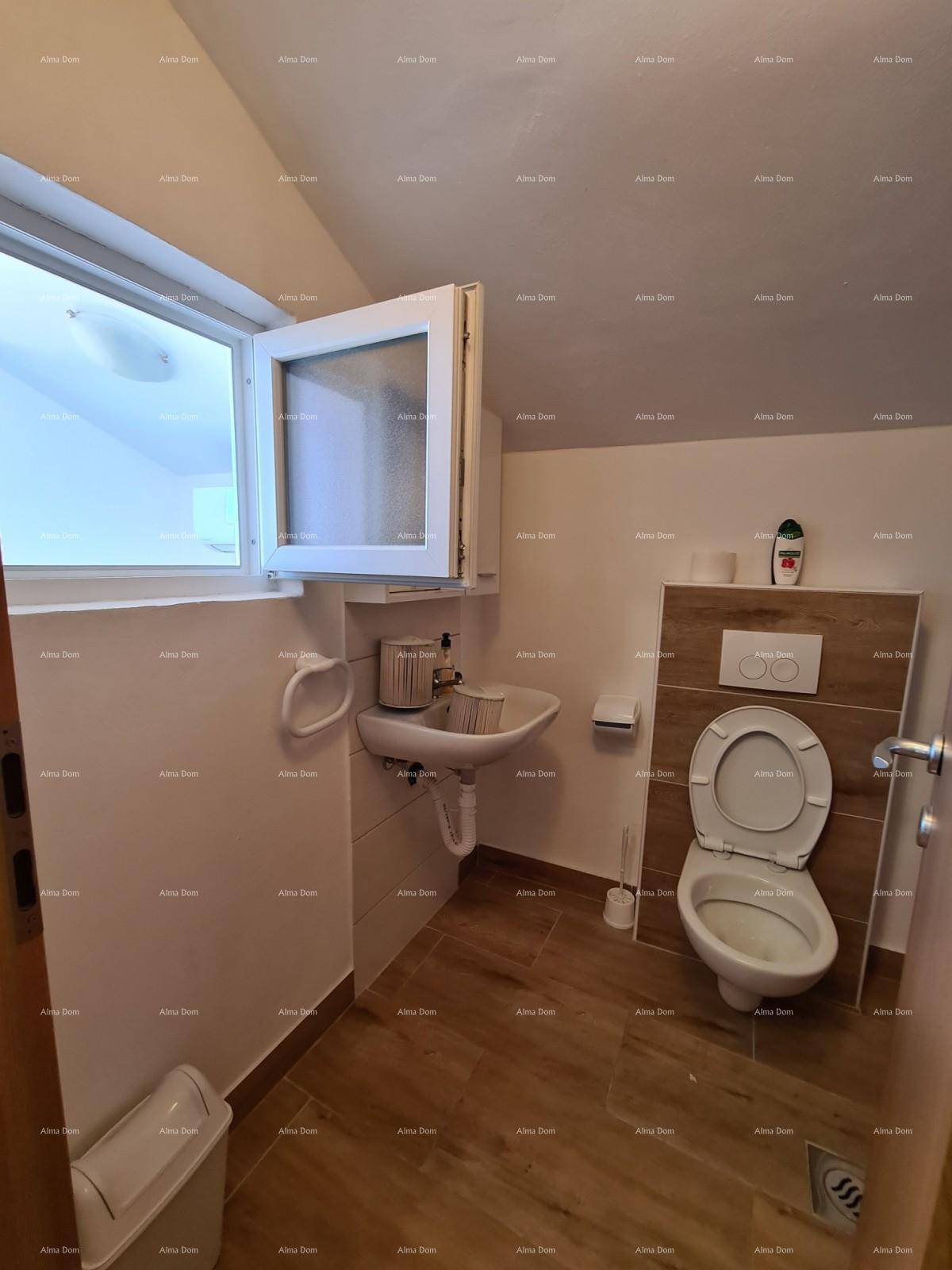 Helles Badezimmer mit Fenster, wandhängendem WC und Waschbecken.