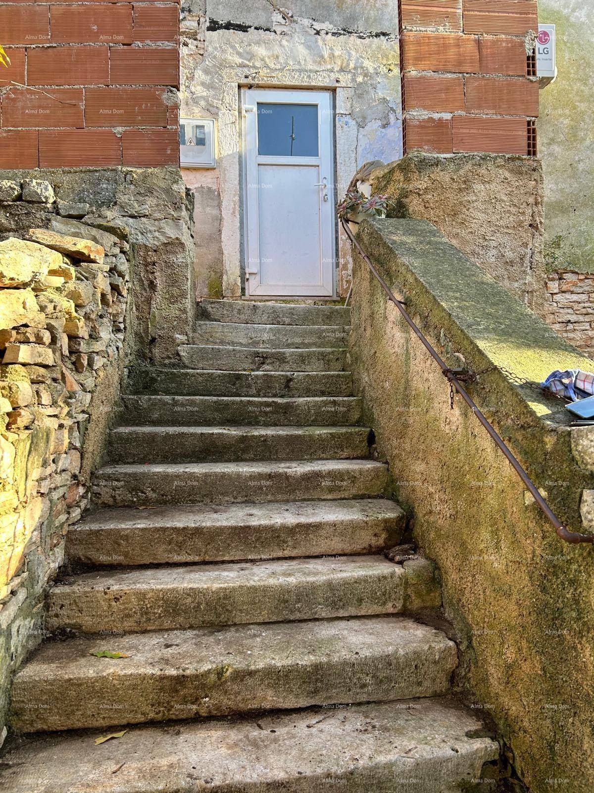Steinerne Außentreppe führt zu einem Eingang in einem alten, rustikalen Gebäude.