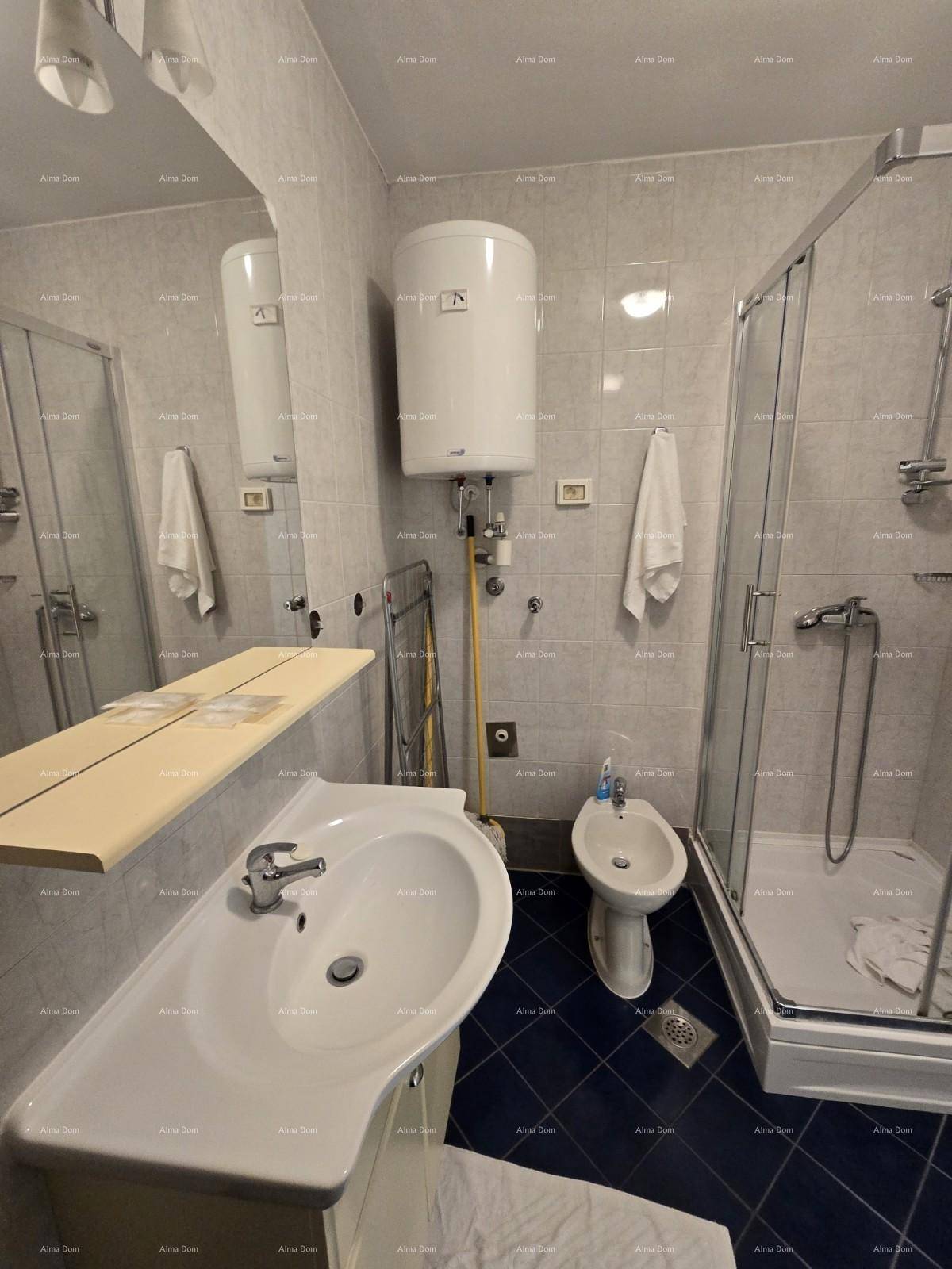 Funktionales Badezimmer mit Duschkabine, Bidet und Waschbecken, komplett gefliest für einfache Pflege.