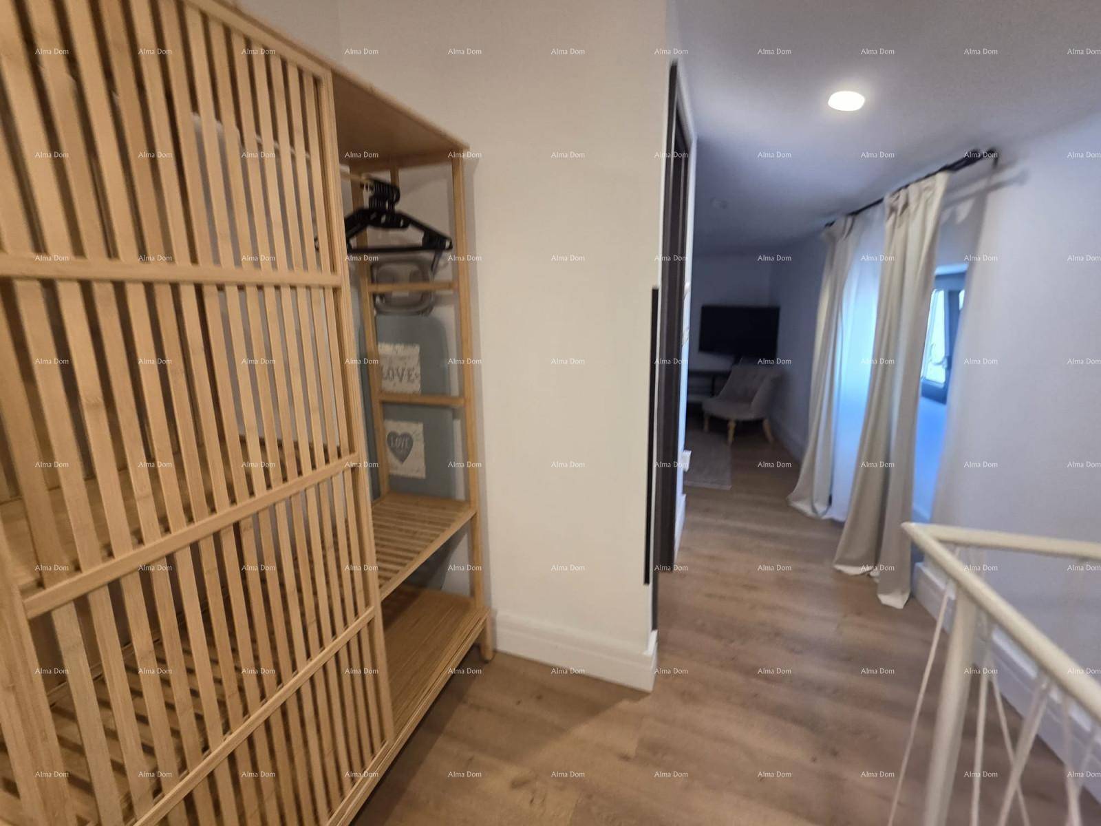 Heller Flur mit Holzfußboden, offenem Kleiderschrank und Blick in ein angrenzendes Schlafzimmer.