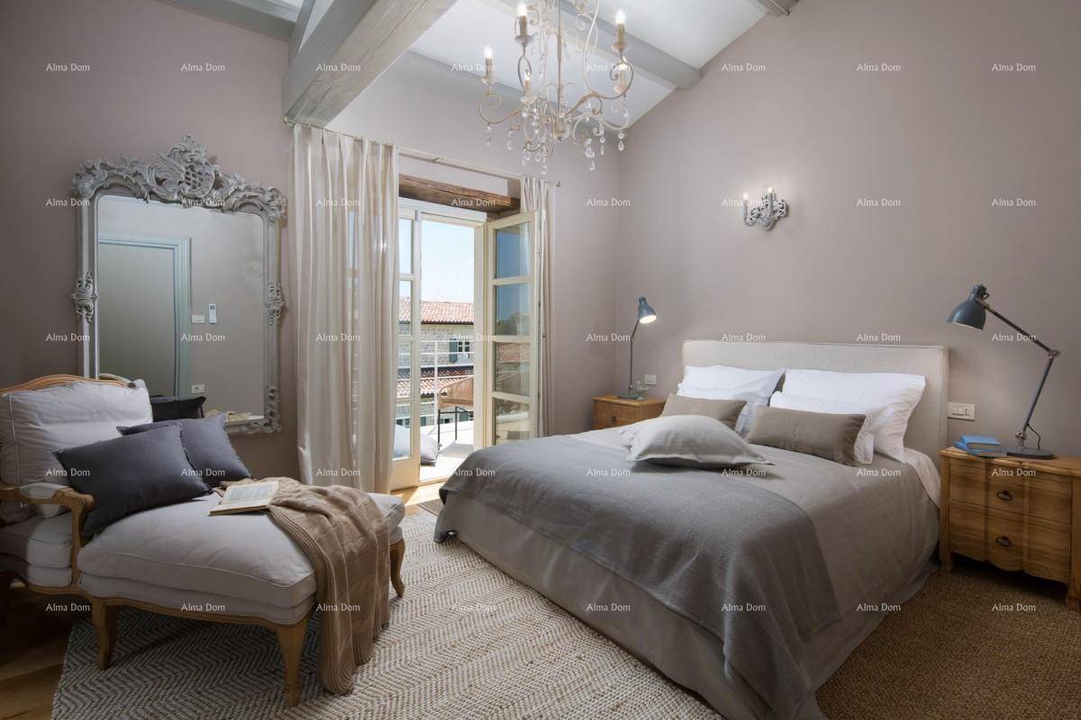 Elegantes Schlafzimmer mit Doppelbett, Holzboden und Zugang zu einem Balkon.
