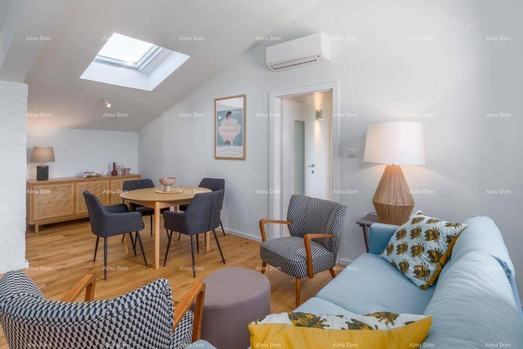 Gemütlicher Wohn-Essbereich mit Esstisch, Sofa, Holzboden und einem Dachfenster für viel Licht.