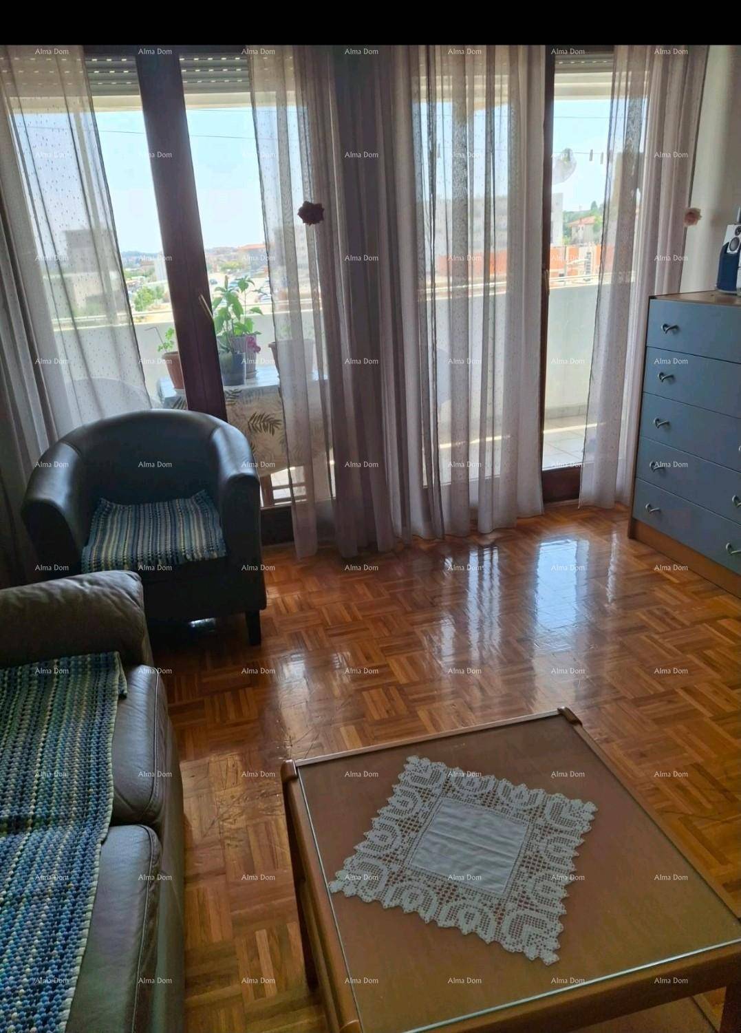 Helles Wohnzimmer mit Parkettboden, bequemen Möbeln und Zugang zu einem Balkon mit Weitblick.