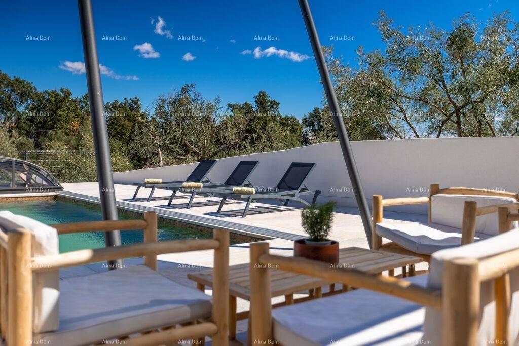 Gemütlicher Terrassenbereich mit Sitzgelegenheiten und Blick auf den Pool und die Natur.