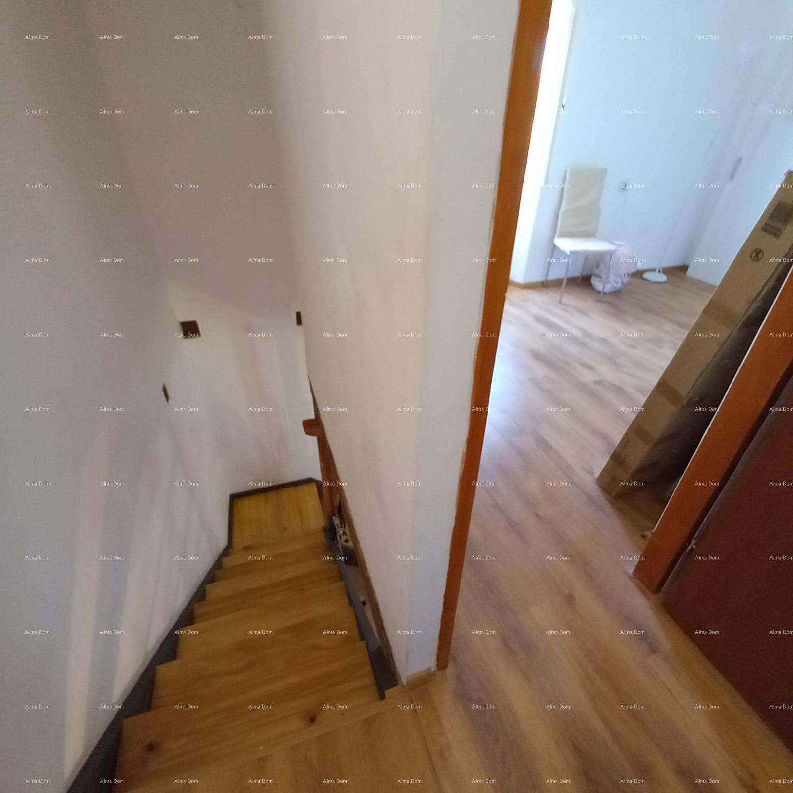 Heller Treppenaufgang mit Holzstufen und Laminatboden im oberen Flurbereich.