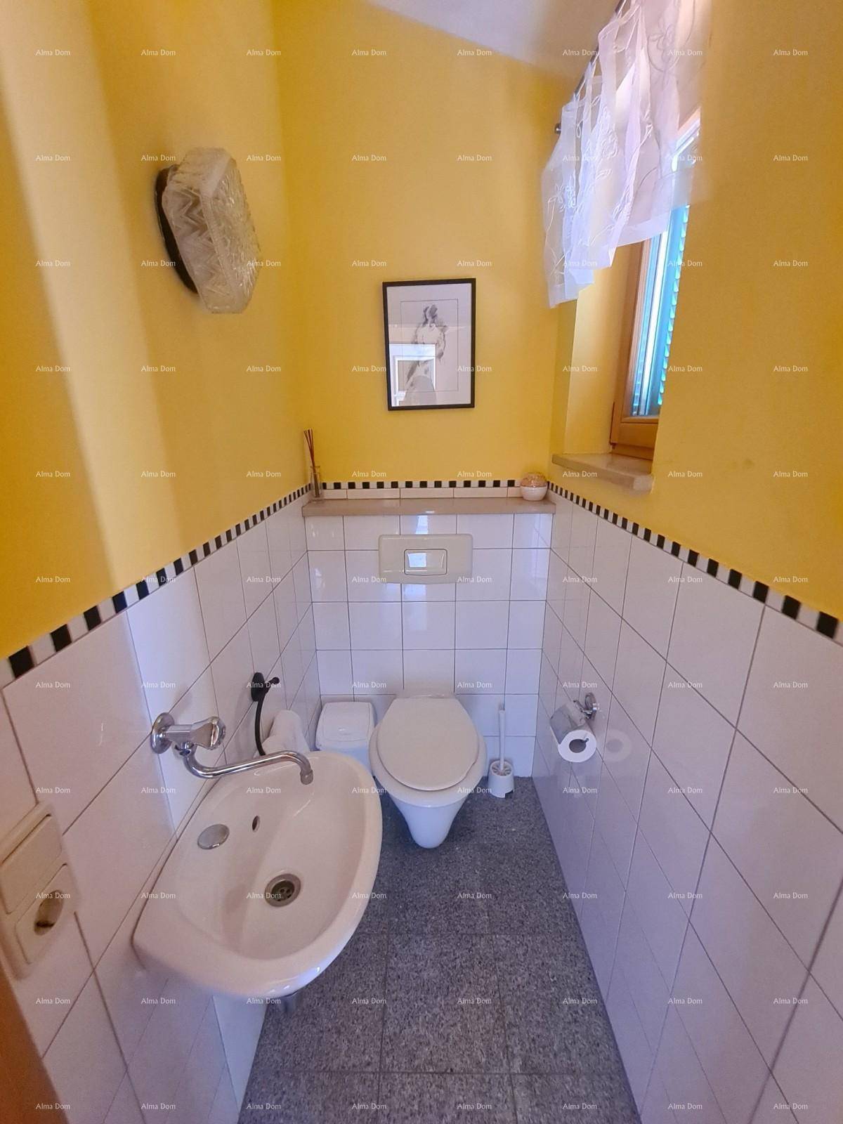 Kleines Gäste-WC mit gelben Wänden, weißen Fliesen, Toilette, Waschbecken und Fenster.