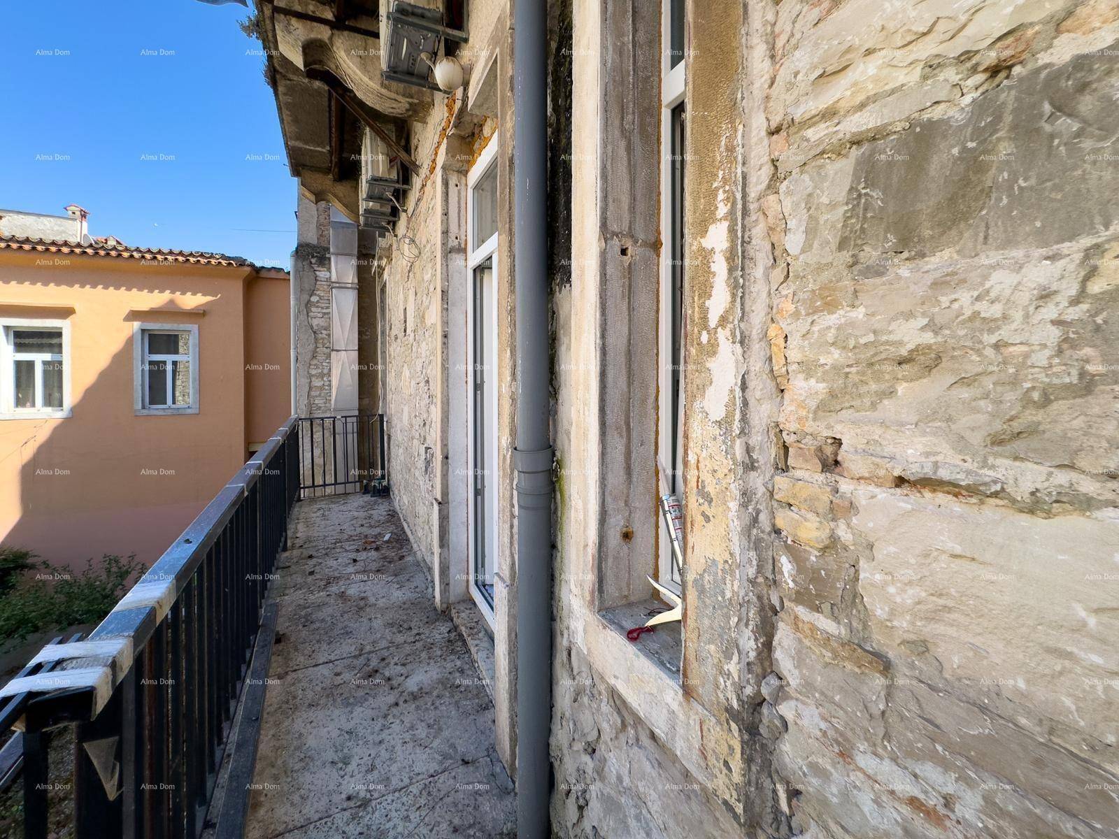 Schmaler Balkon entlang einer alten Steinfassade mit Blick auf die Nachbargebäude.