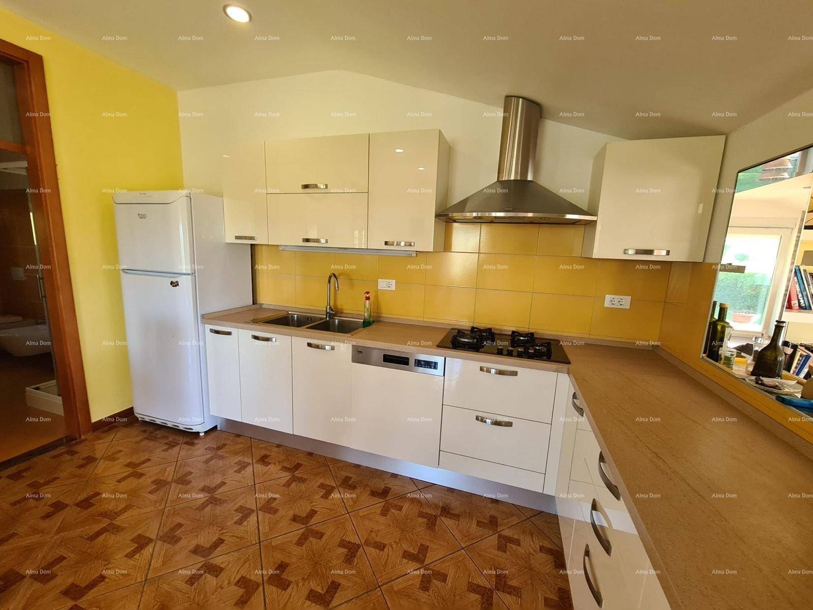 Funktionale Küche mit weißen Schränken, gelbem Fliesenspiegel, Kühlschrank und Arbeitsflächen aus Holz.