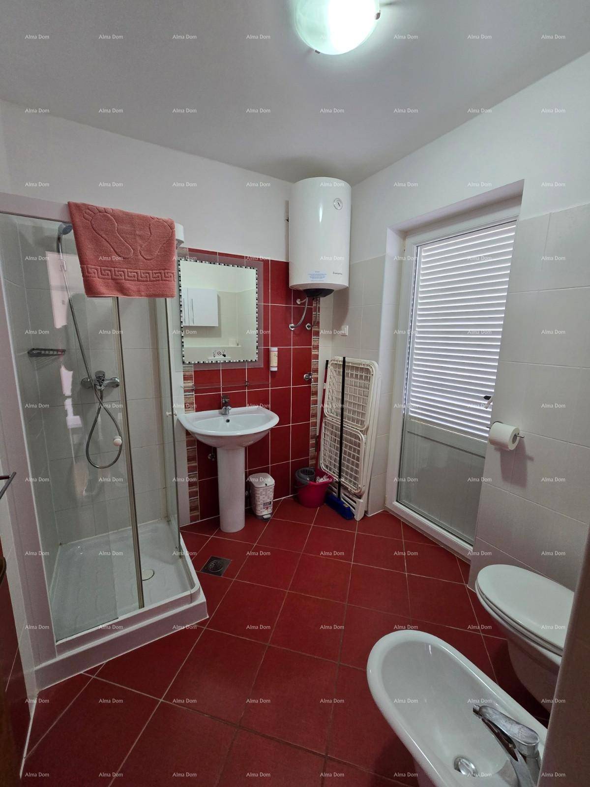 Badezimmer mit roten Fliesen, Duschkabine, Waschbecken, Toilette und Bidet.