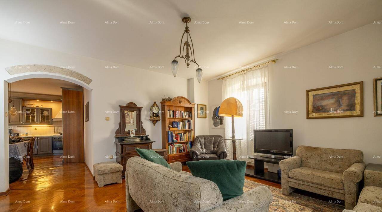 Wohnzimmer mit Parkettboden und einem Durchgang zum Essbereich, eingerichtet im klassischen Stil.