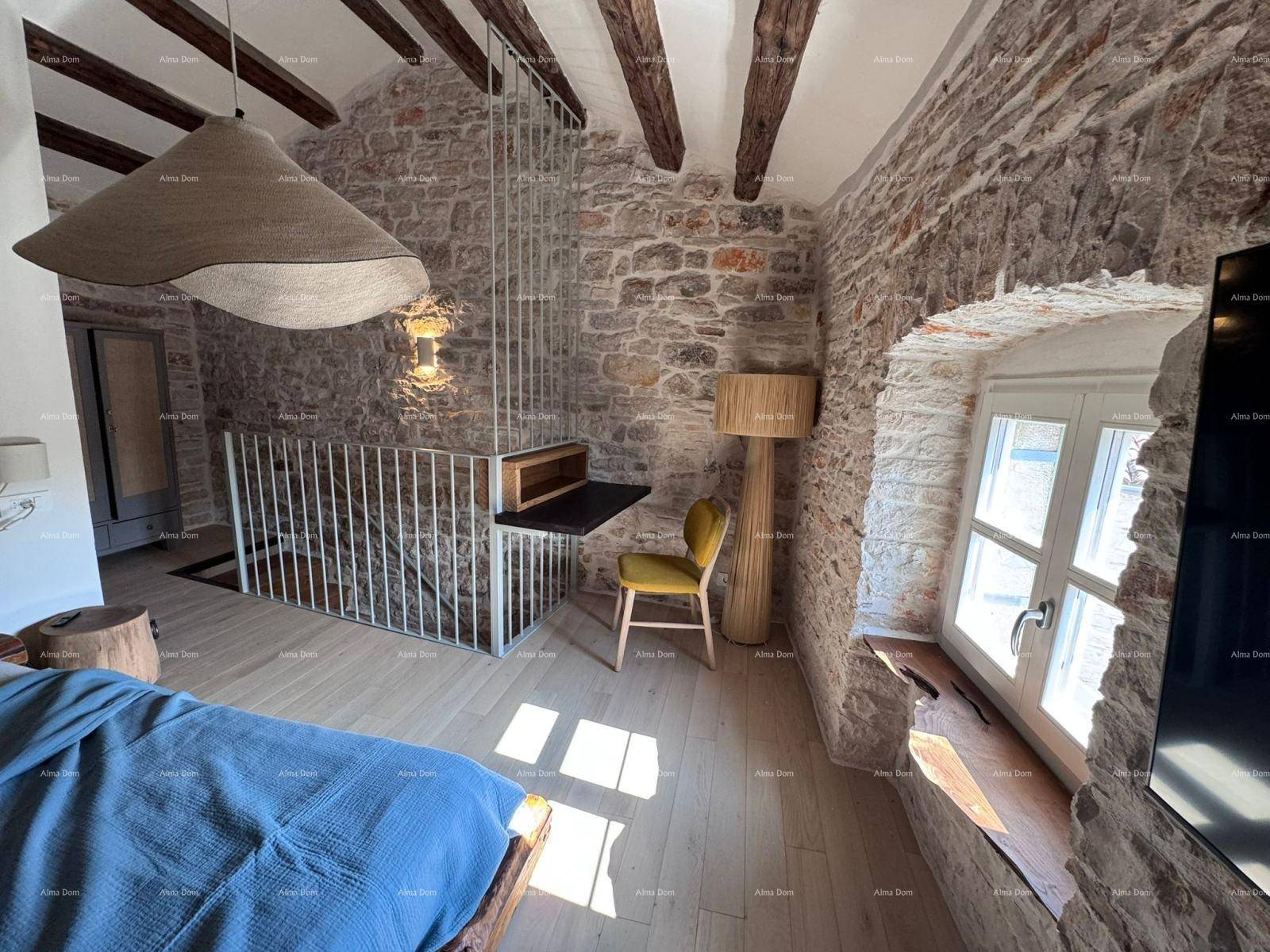 Helles Schlafzimmer mit Holzboden, Steinwänden und einem kleinen Arbeitsbereich.