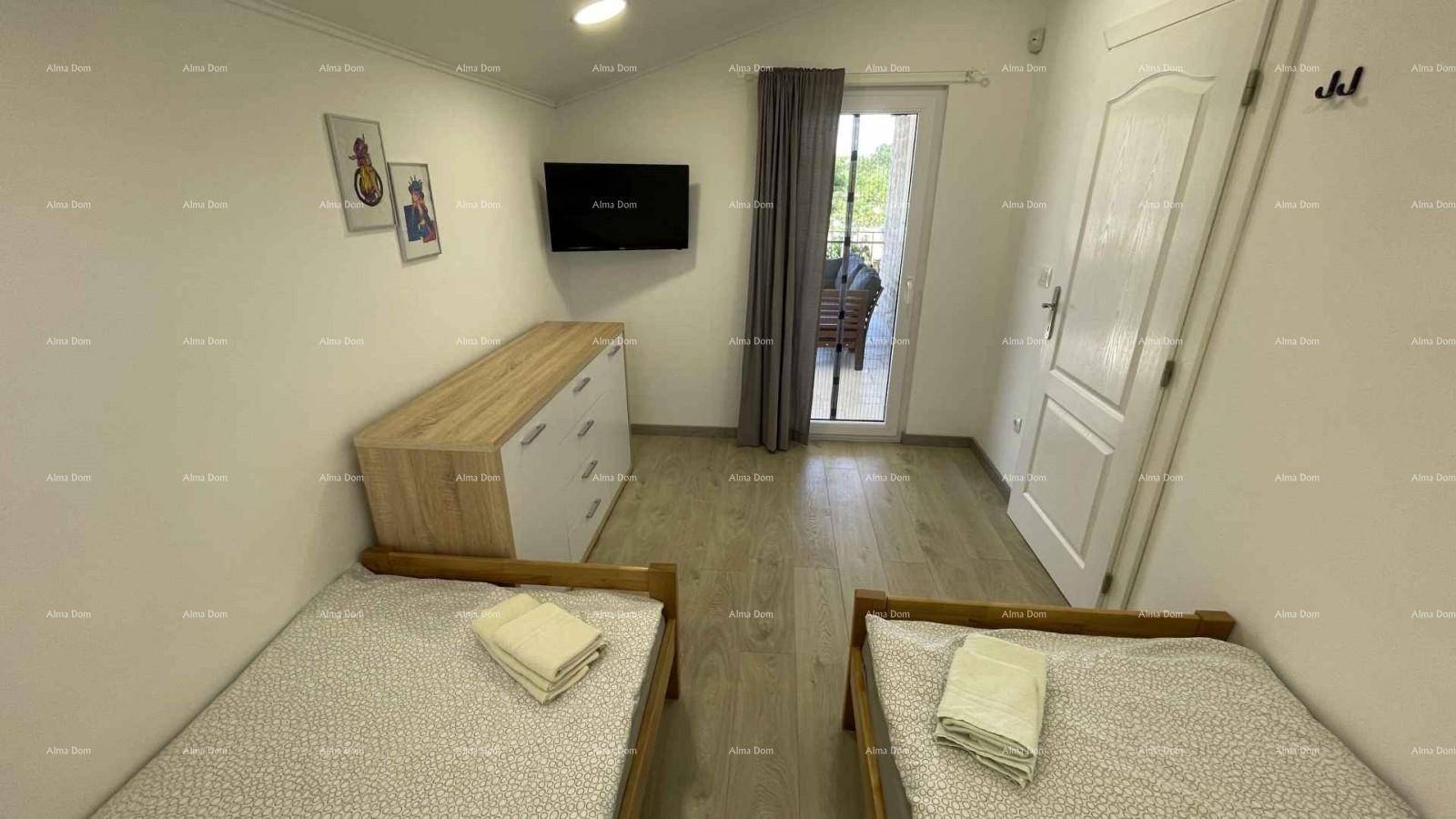 Schlafzimmer mit zwei Einzelbetten, Kommode und Zugang zu einem Balkon.
