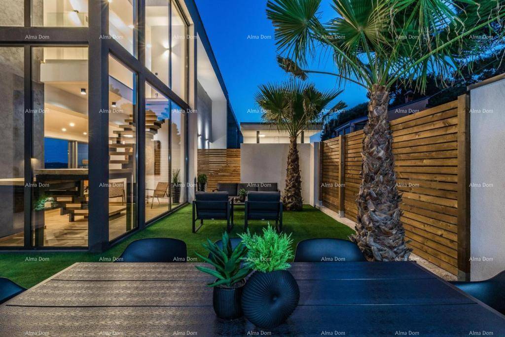 Gepflegter Garten mit Essbereich im Freien und Blick auf die moderne Glasfassade der Villa.