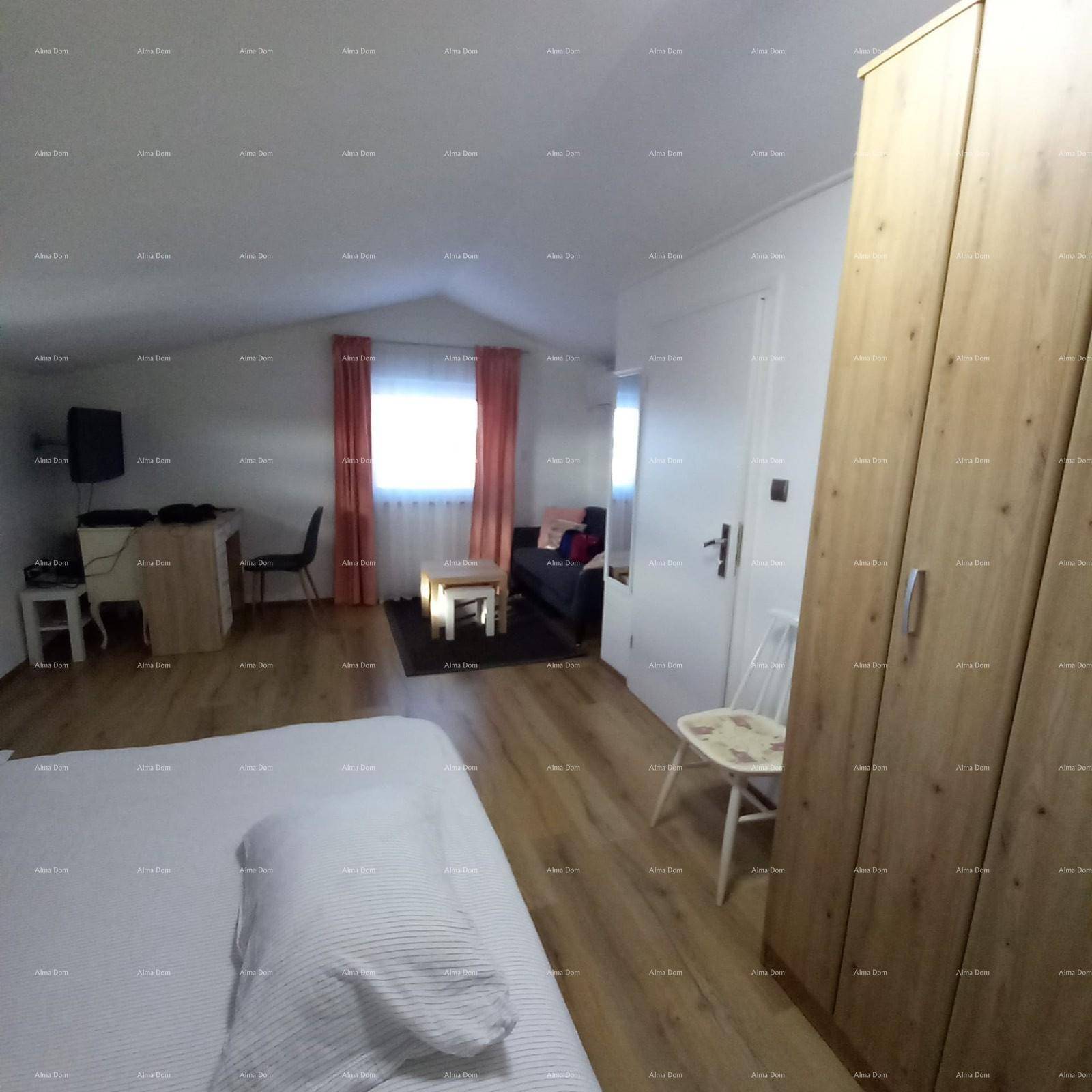 Geräumiges Schlafzimmer im Dachgeschoss mit Holzkleiderschrank und Dachschräge.