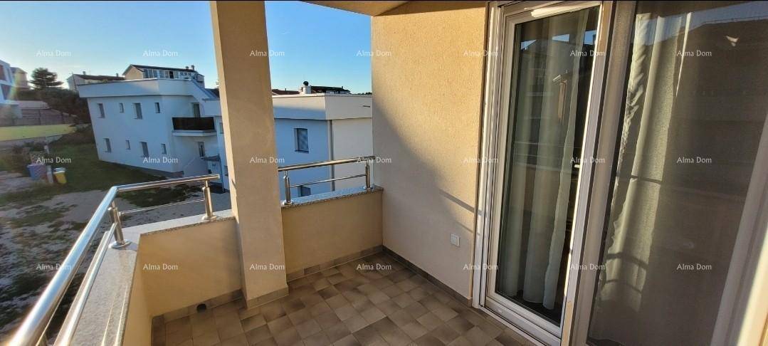 Geräumiger Balkon mit Fliesenboden und Blick auf die umliegenden Gebäude und das Meer.