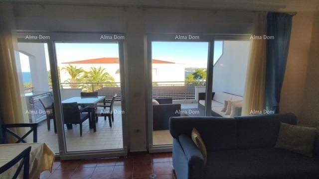 Helles Wohnzimmer mit großen Schiebetüren, die den Blick auf die möblierte Terrasse freigeben.