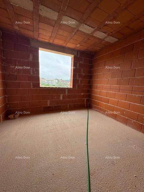Rohbau-Zimmer mit Ziegelwänden, einer Fensteröffnung und Blick auf die Umgebung.
