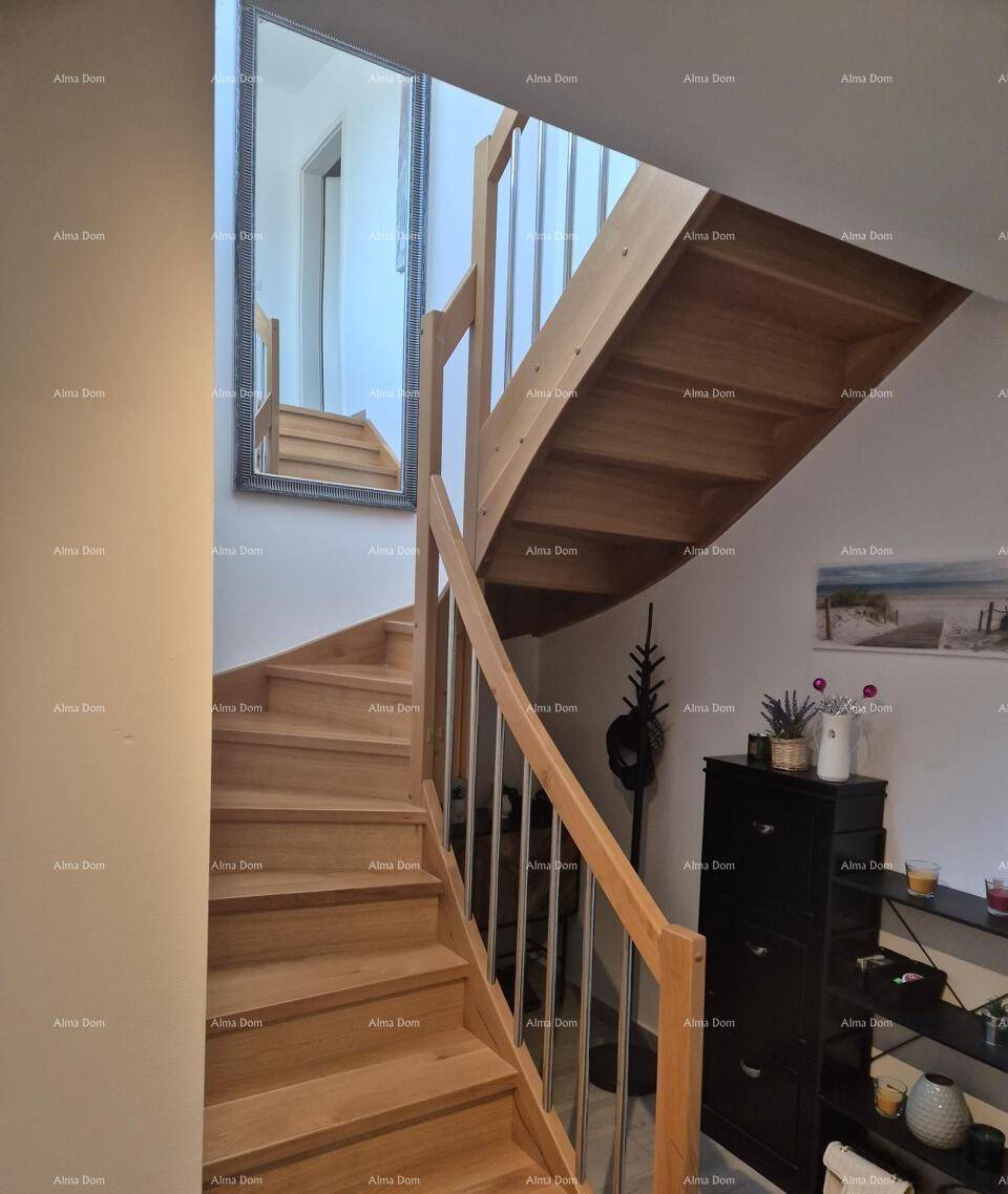 Elegante Holztreppe mit modernen Geländern, die die verschiedenen Etagen des Hauses verbindet.