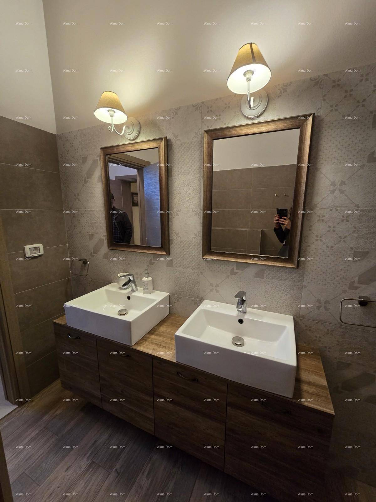 Elegantes Badezimmer mit zwei Waschbecken, Holzunterschrank und passenden Spiegeln.
