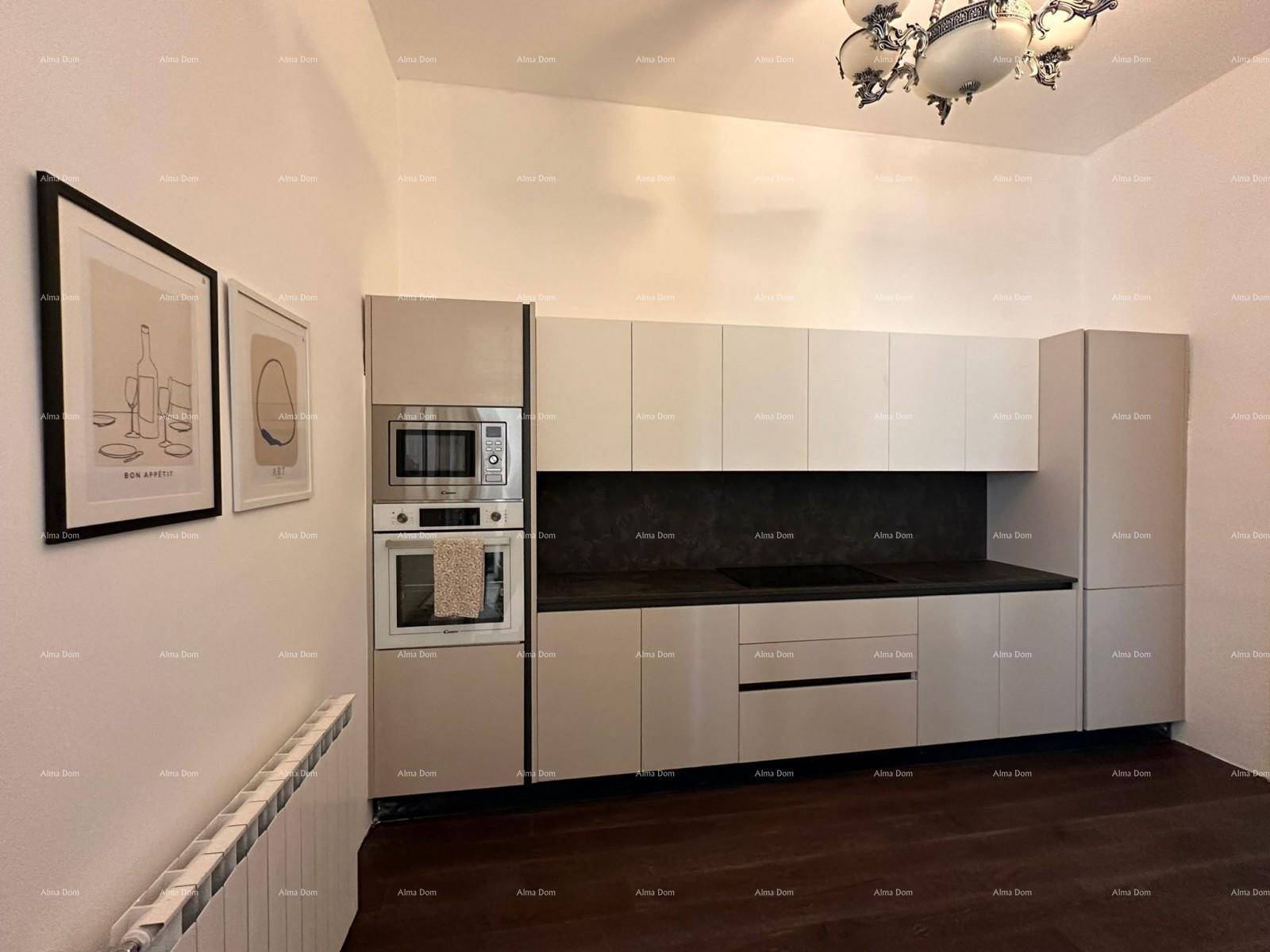 Moderne Einbauküche mit hellen Fronten, dunkler Arbeitsplatte und integriertem Backofen und Mikrowelle.