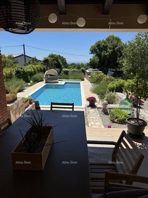 Überdachte Terrasse mit Esstisch und Blick auf den Pool und den gepflegten Garten.