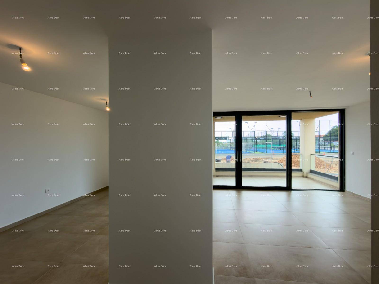 Offener Wohnbereich mit Fliesenboden, großen Glasfronten und Blick auf die Außenanlage mit Sportplätzen.