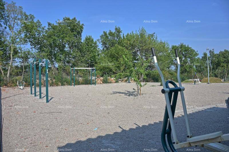 Outdoor-Fitnessbereich mit verschiedenen Geräten in natürlicher Umgebung.