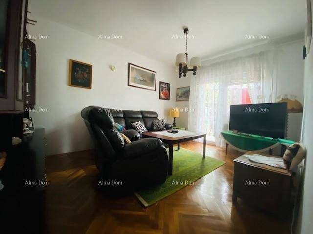 Gemütliches Wohnzimmer mit dunklem Ledersofa, Couchtisch und Parkettboden.