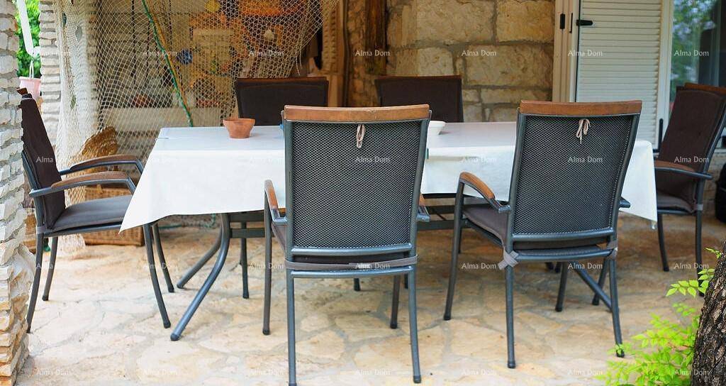 Gemütlicher Essbereich im Freien mit robusten Stühlen und einem gedeckten Tisch auf der Terrasse.