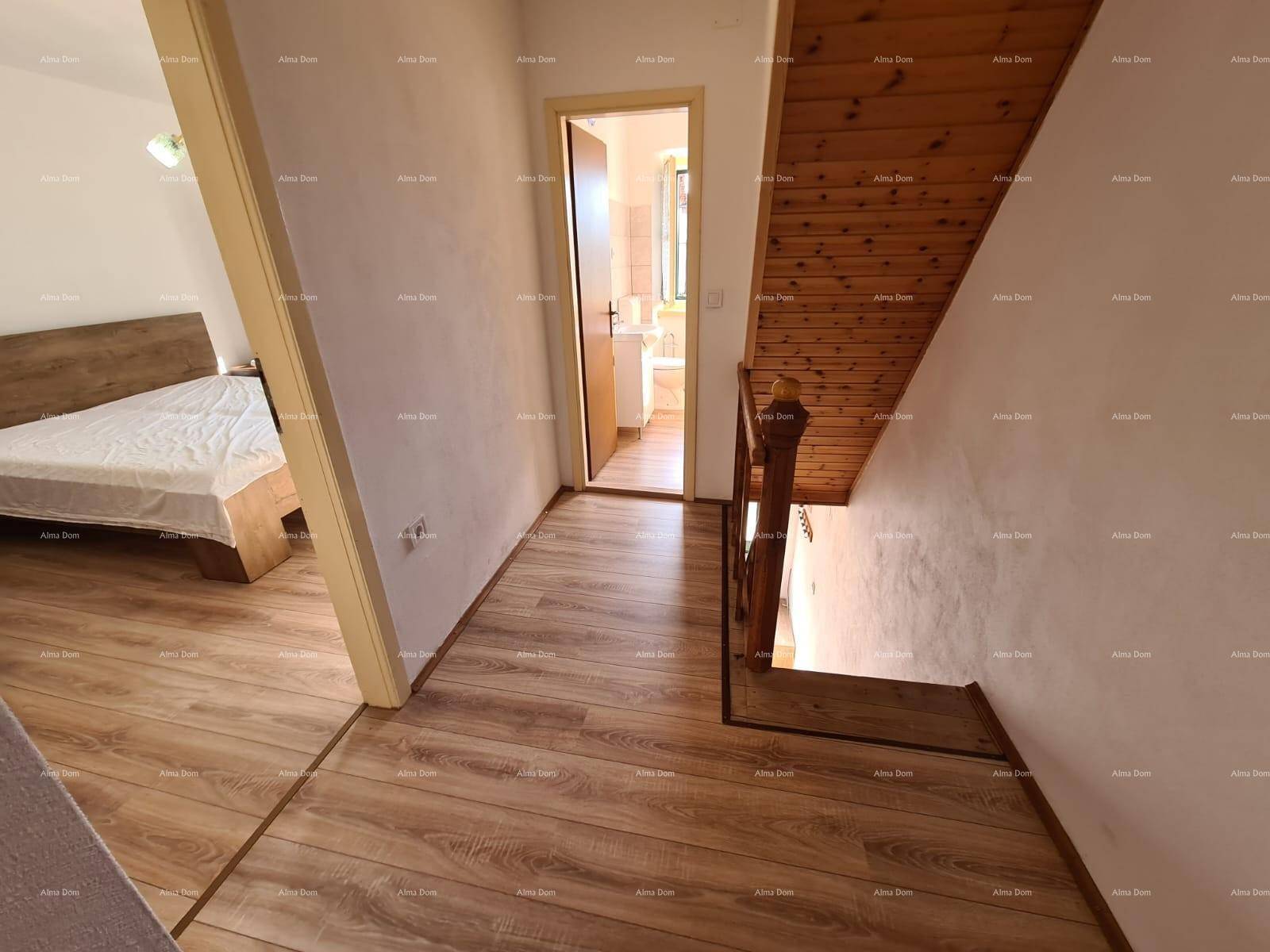 Flur mit Holzboden, Treppe und Zugang zu einem Schlafzimmer und einem Badezimmer.