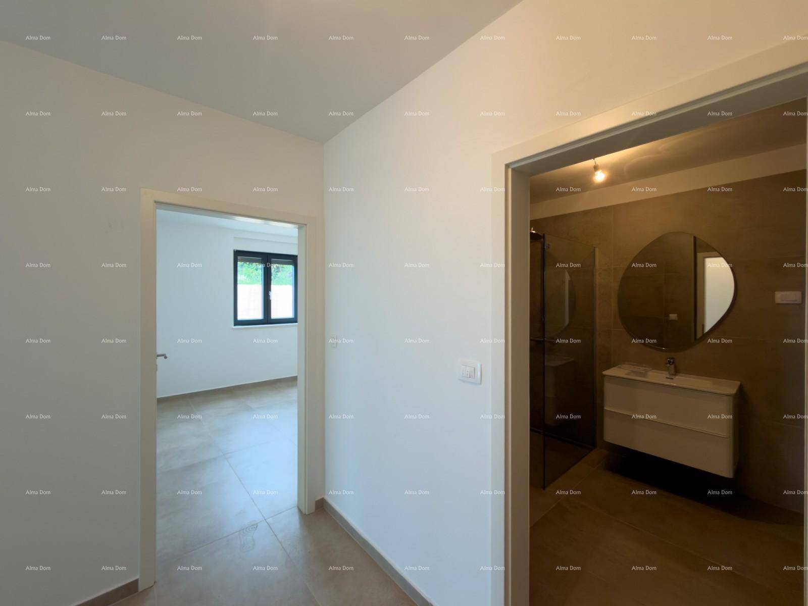 Flur mit Zugang zu einem modernen Badezimmer mit Waschtisch und einem hellen Schlafzimmer.