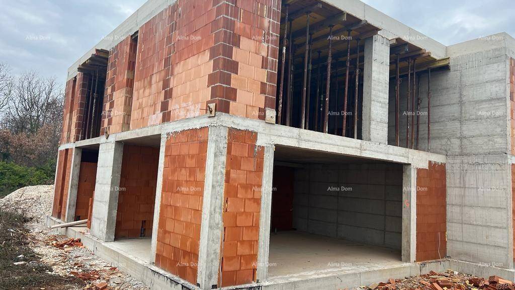 Rohbau eines Hauses mit sichtbaren Ziegelwänden und Betonstrukturen während der Bauphase.