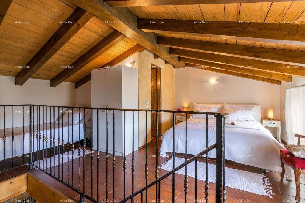 Schlafzimmer im Dachgeschoss mit Holzbalken, Holzboden und offener Galerie.