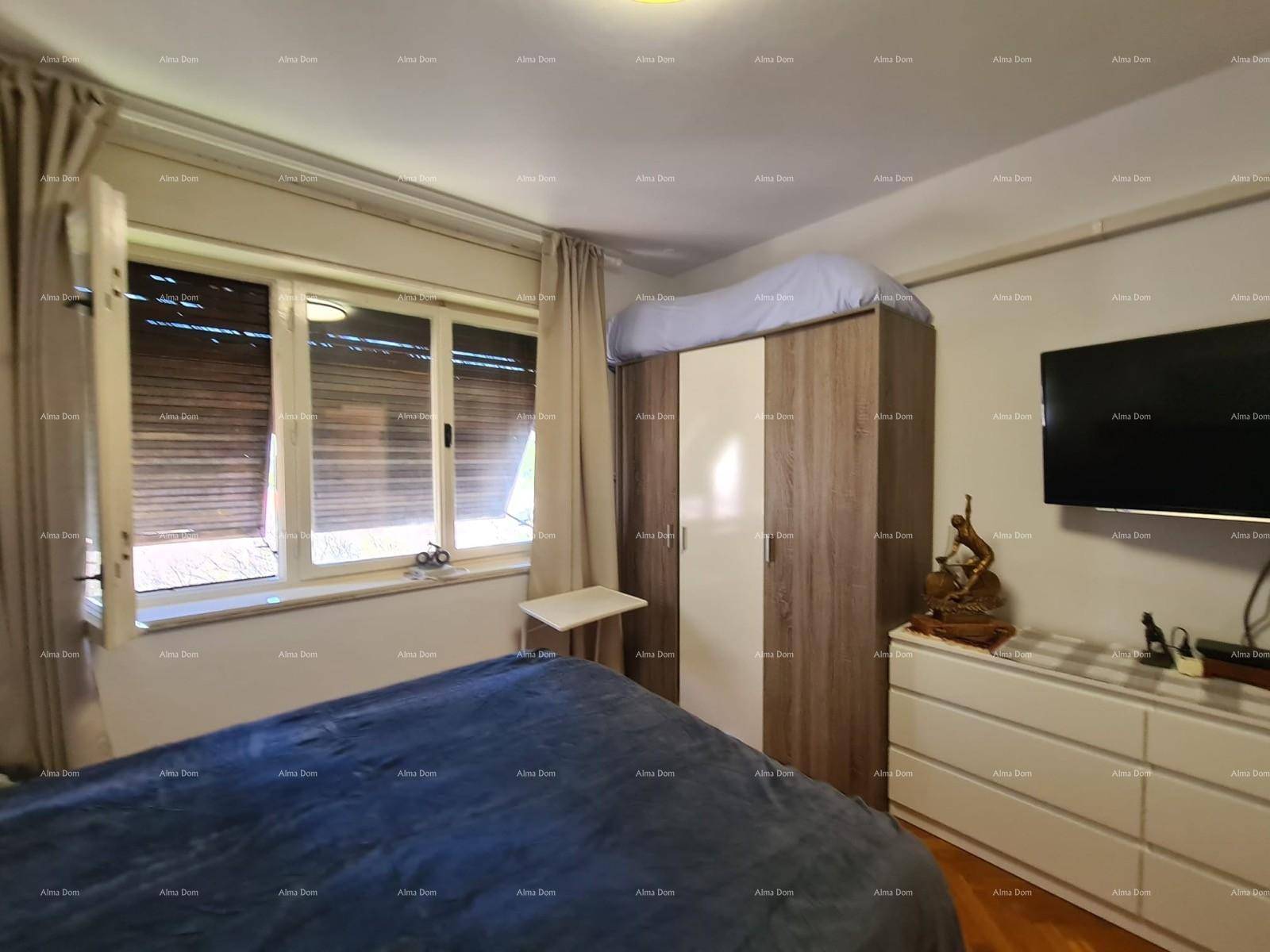Schlafzimmer mit Kleiderschrank, Kommode und Fenster mit Blick nach draußen.