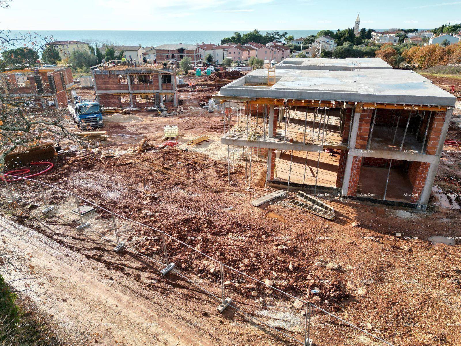 Baustelle mit mehreren Rohbauten und Blick auf das Meer und die Küste.