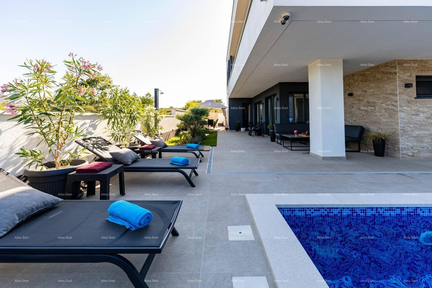 Sonniger Poolbereich mit bequemen Liegestühlen und mediterraner Bepflanzung für entspannte Stunden.