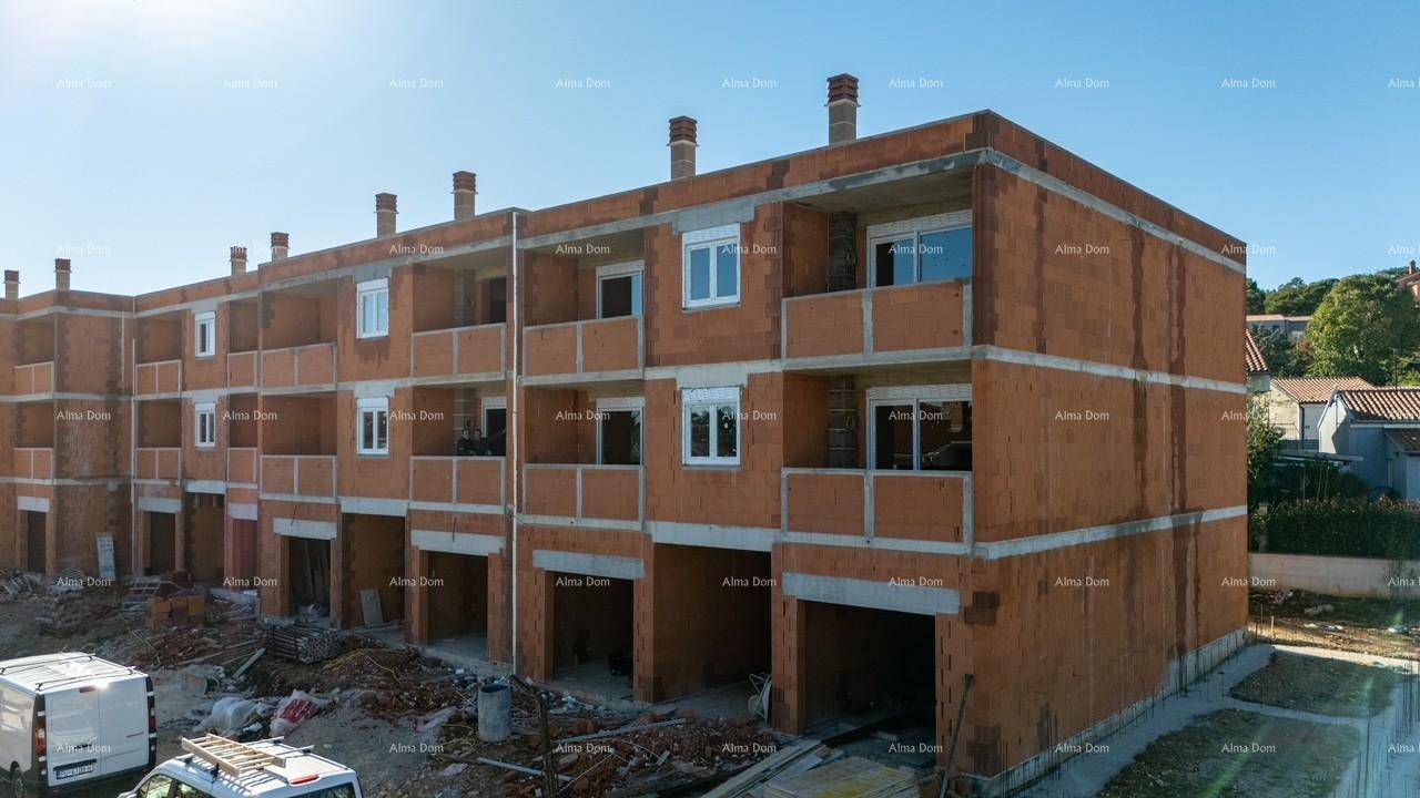 Ansicht des im Bau befindlichen Gebäudes mit sichtbaren Ziegelwänden und zukünftigen Balkonbereichen.