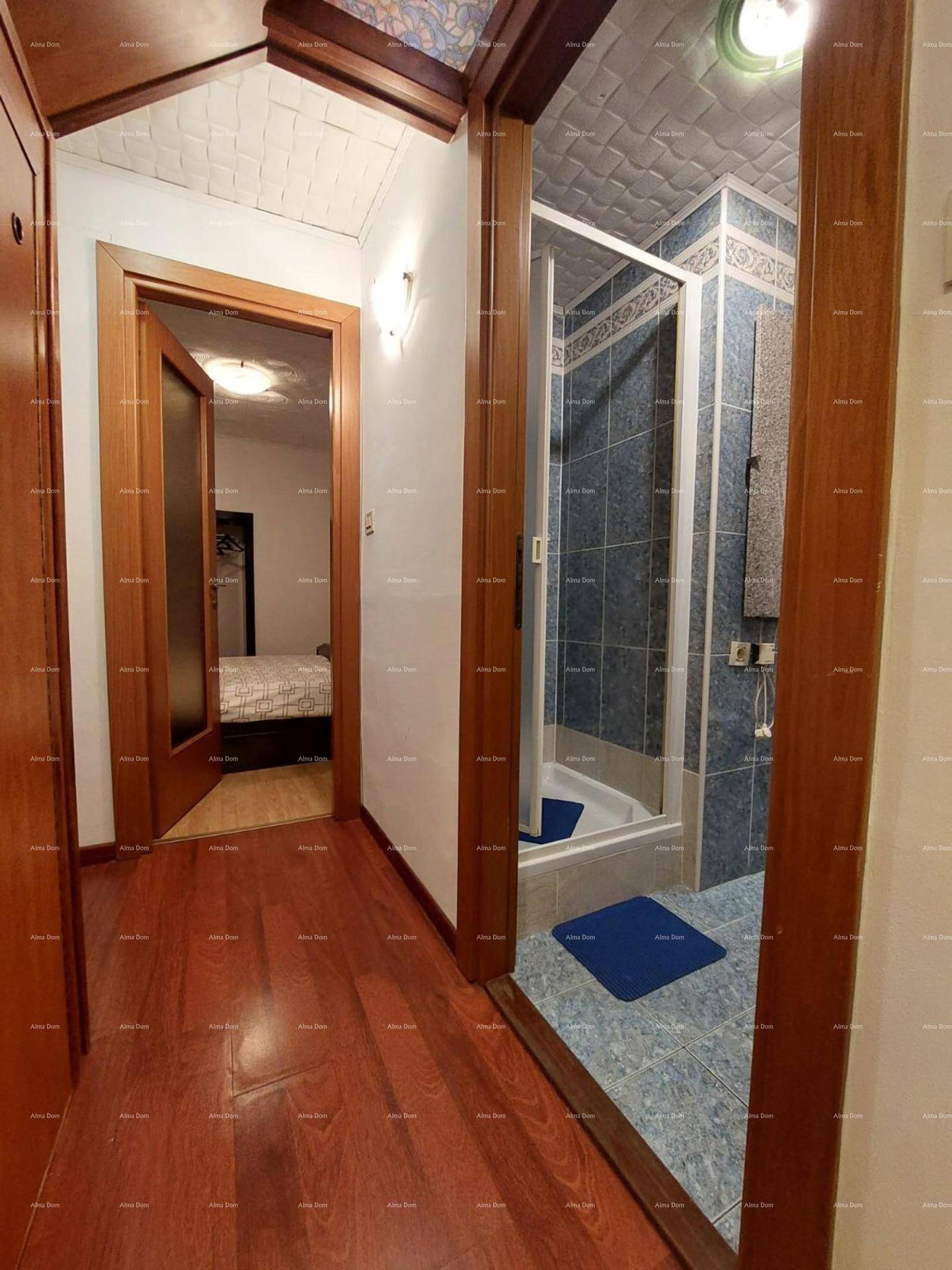 Flur mit Holzboden und Zugang zu Schlafzimmer und Badezimmer.