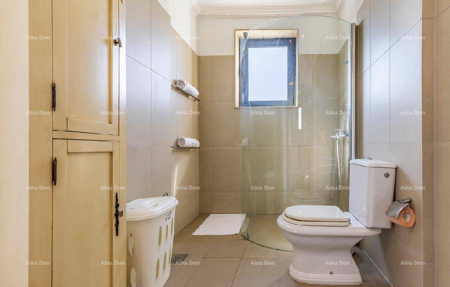 Praktisches Badezimmer mit Toilette, Duschkabine und einem Fenster im Duschbereich.